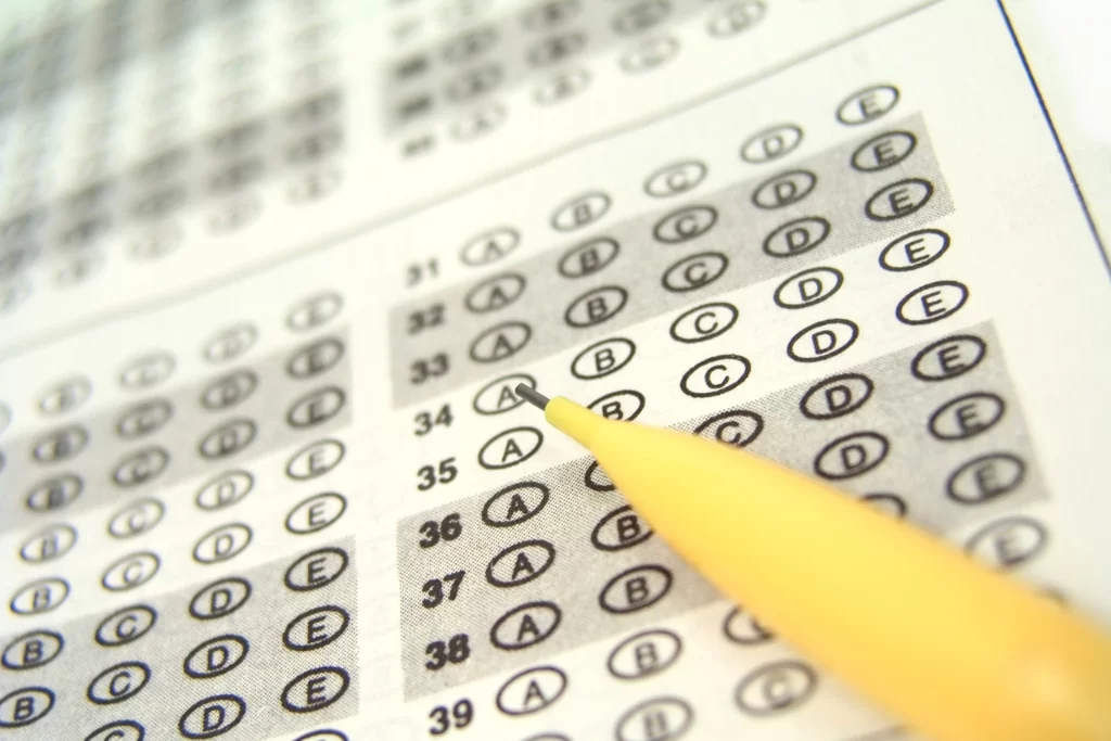 Folha de respostas de concurso público com questões da FCC marcadas por um lápis grafite amarelo