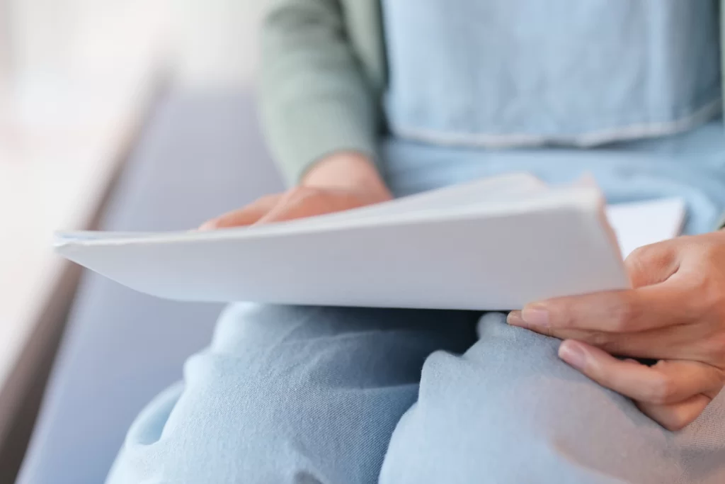 Mãos seguram folhas de papel com questões de semântica para concurso público