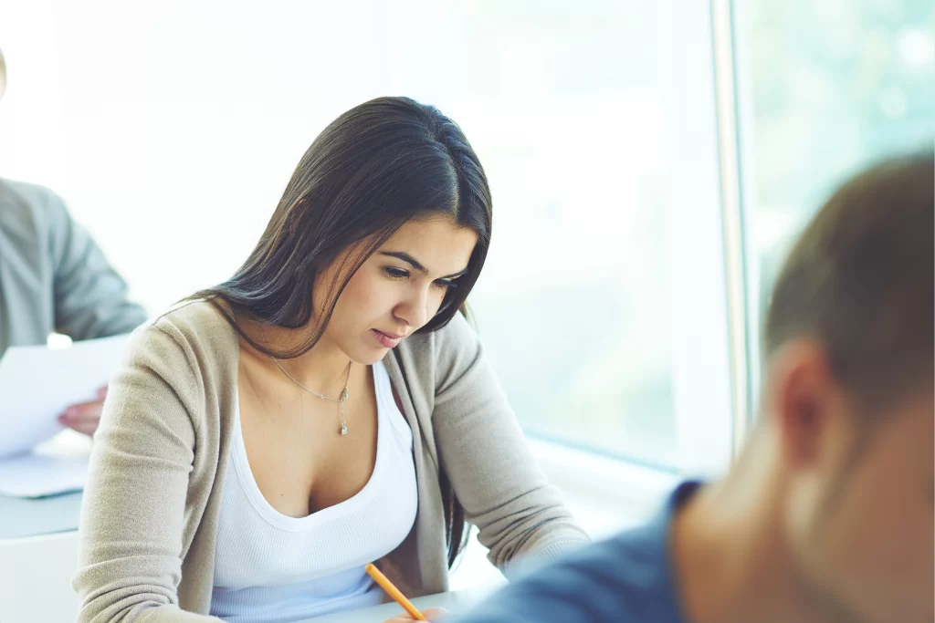 Concurseiros resolvendo questões de transitividade verbal em sala de aula