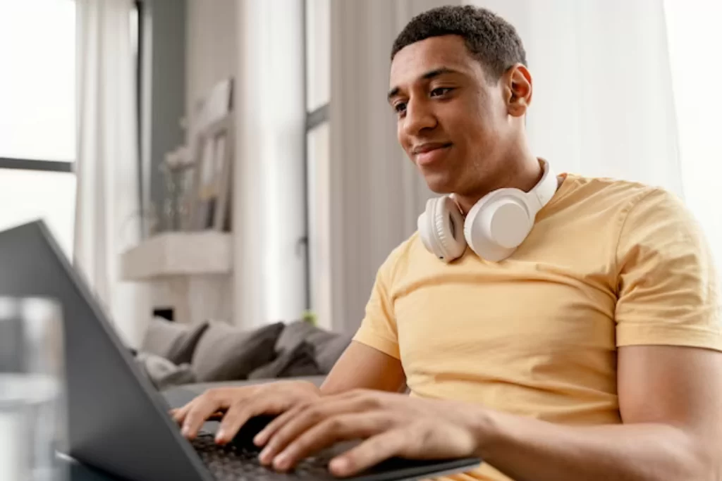 Concurseiro à mesa escrevendo em notebook enquanto estuda Português para concursos do zero  