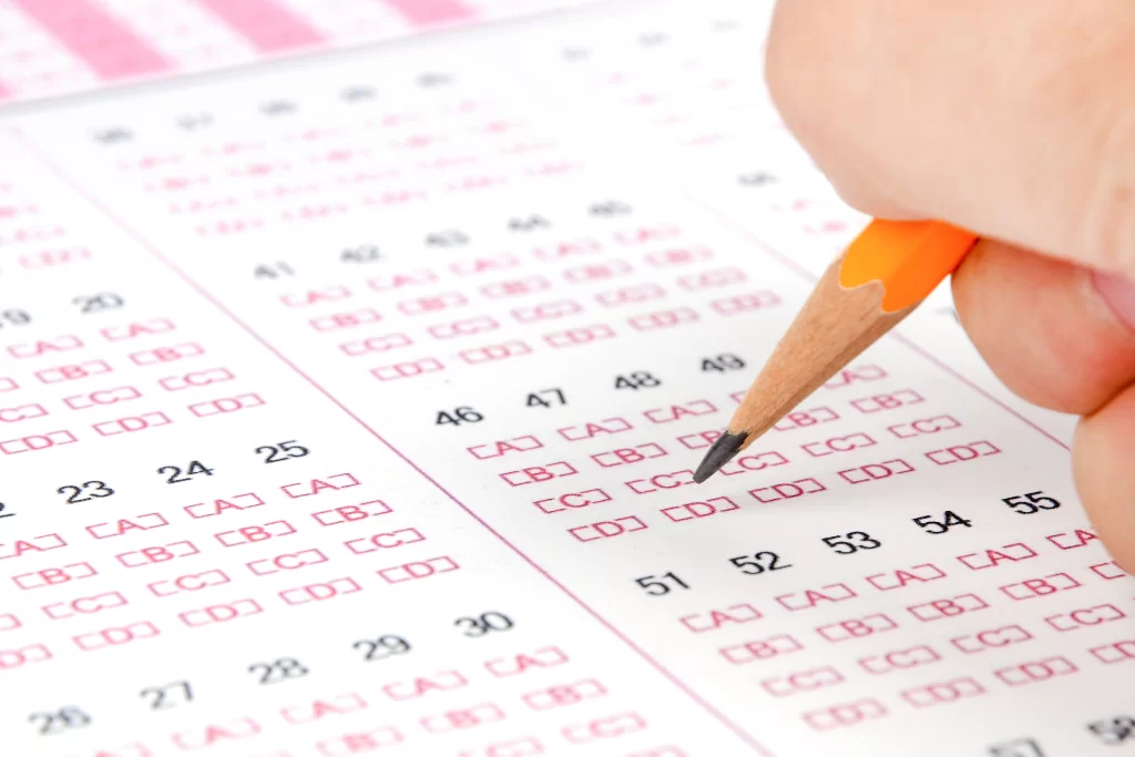 Lápis de madeira amarelo respondendo gabarito de prova com questões sobre intertextualidade